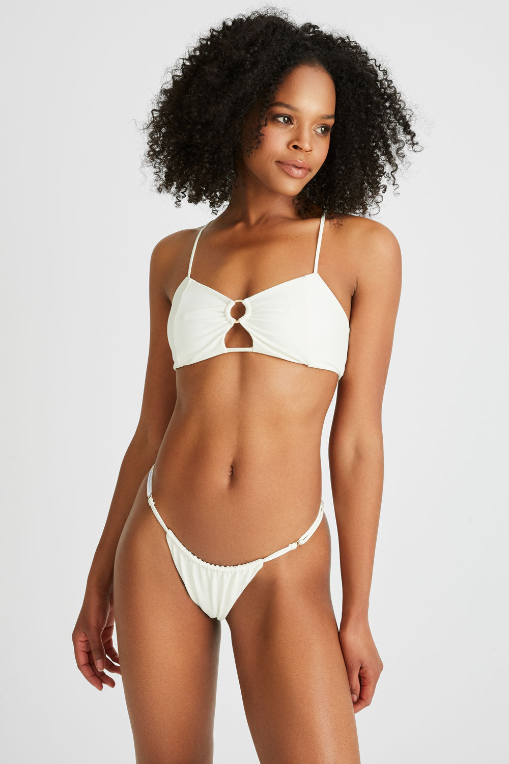 Model wears cheeky white bikini bottoms 