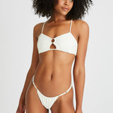 Model wears cheeky white bikini bottoms 