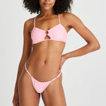 model wears pink bikini set with cross back